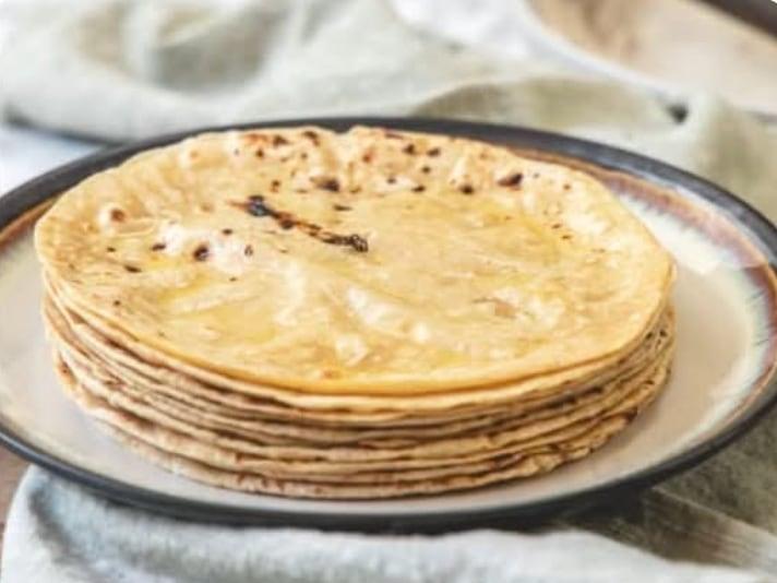 A stack of soft phulka roti on a plate